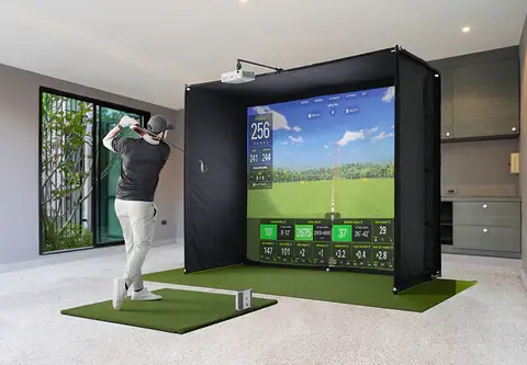 A person practices their golf swing indoors perfectly matched with a state of the art virtual golf simulator This ultimate guide to golfing features a large screen that displays various statistics enhancing the experience and refining skills without stepping outdoors