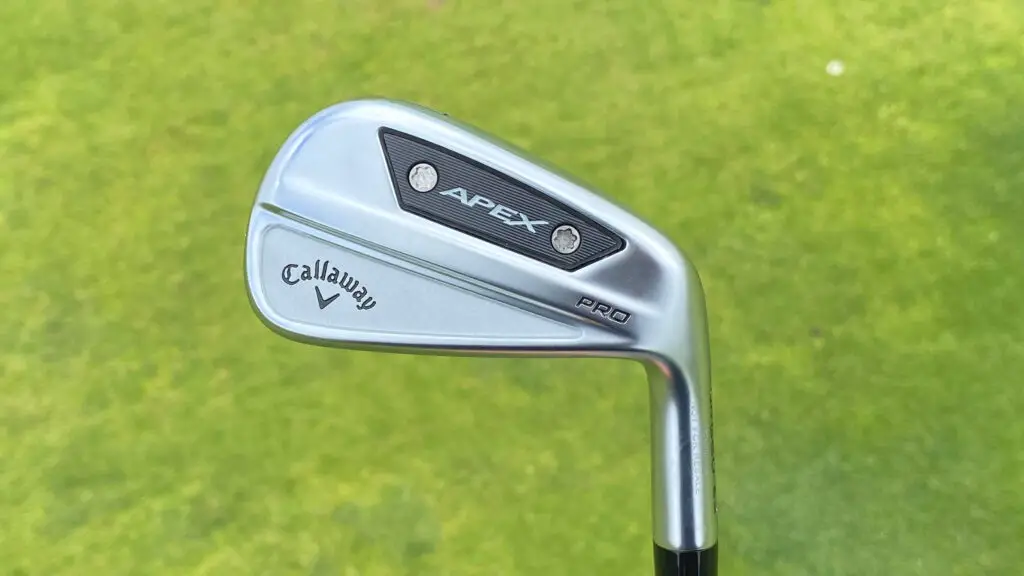 Close up of a Callaway Apex Pro golf club iron one of the best golf irons for  set against a lush grassy background